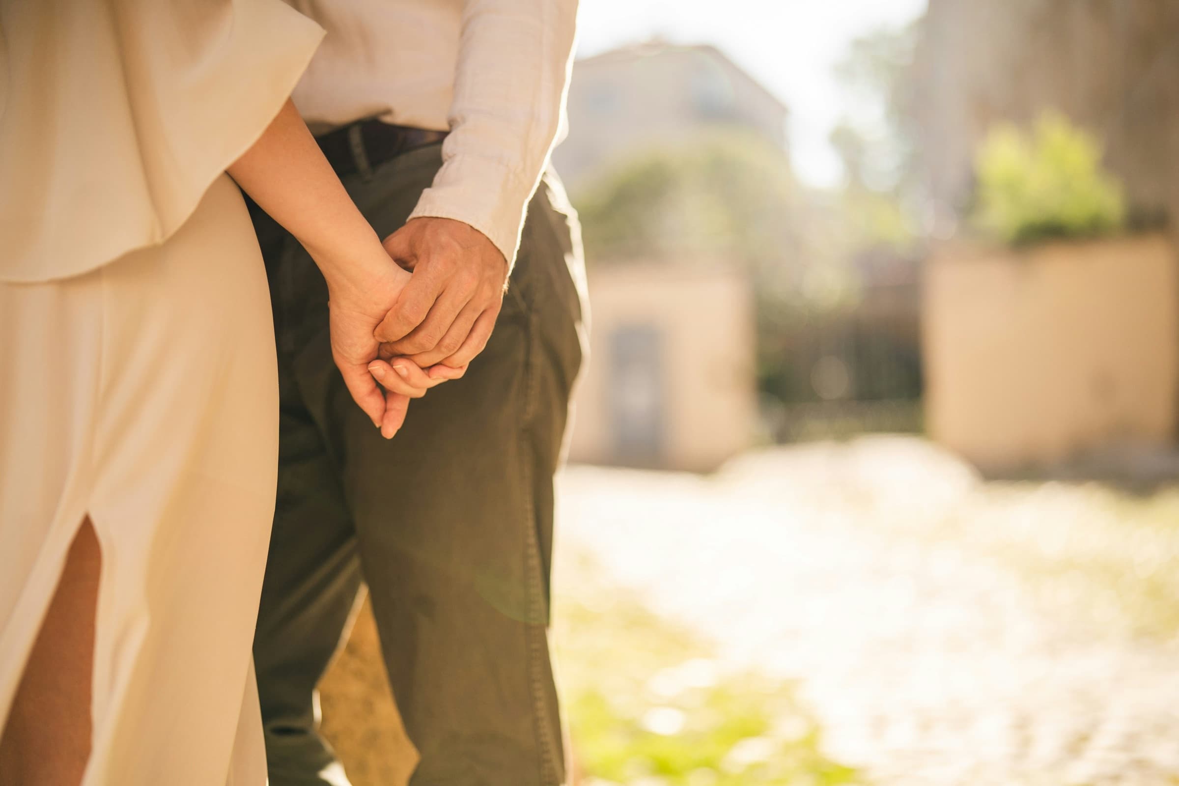 Engaged couple holding hands in warm golden-hour light