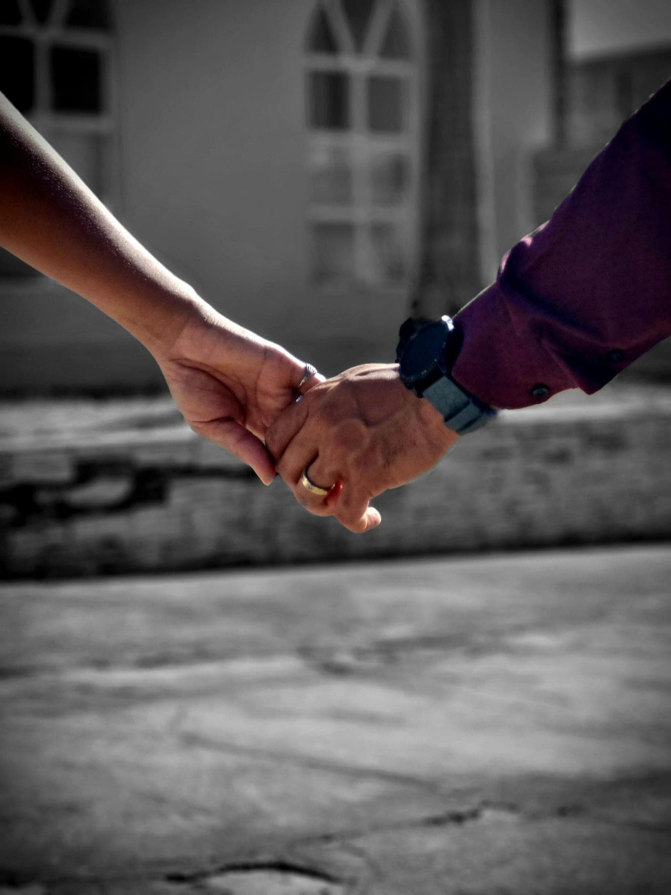 Couple holding hands while walking through a street scene